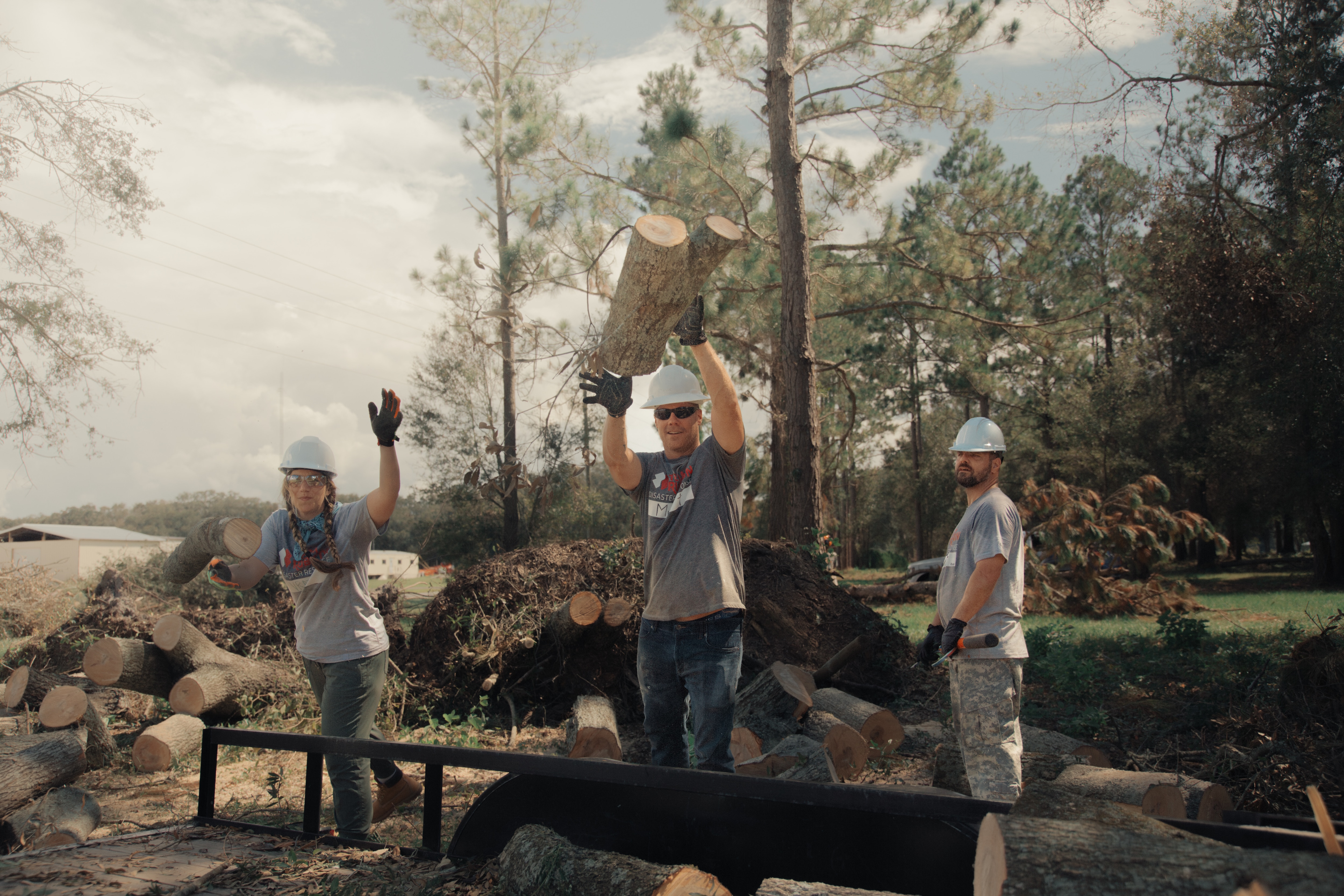 A group of volunteers loads debris onto a trailer. 